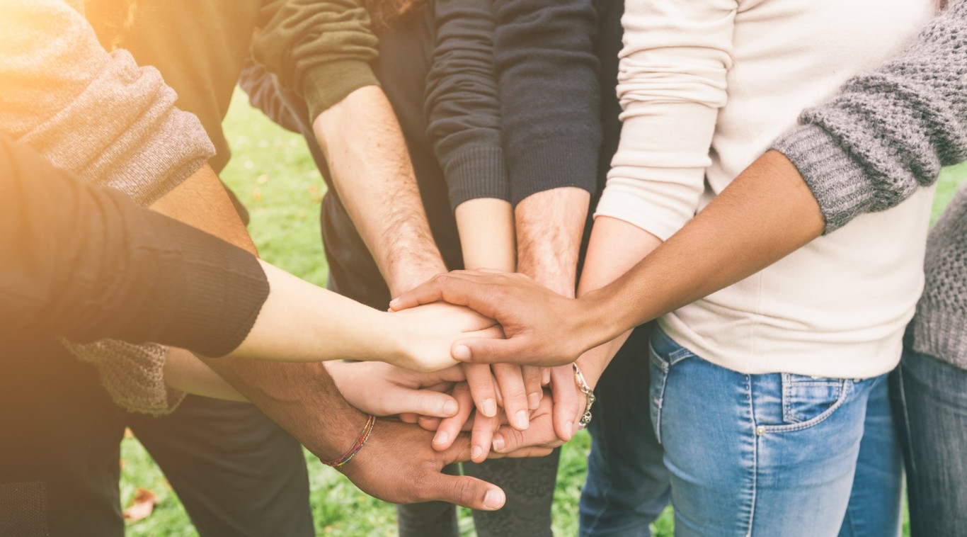 Multiracial group of friends with hands in stack